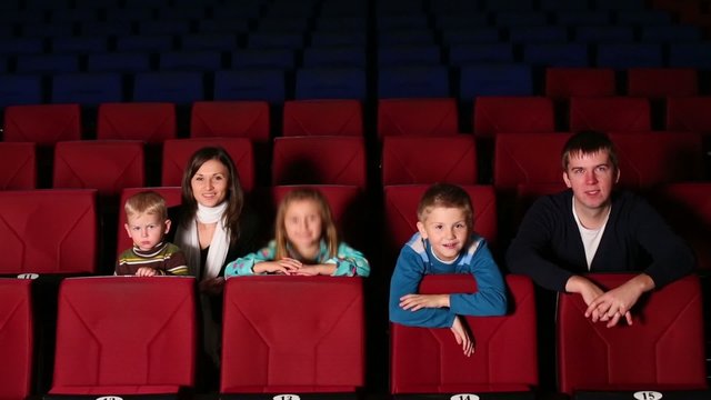 parents with three children in the cinema watching a comedy