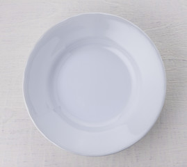 Empty white ceramic plate on wooden table
