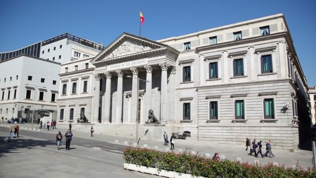 People walk near Spanish Congress of Deputies building