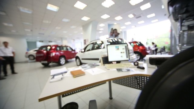 hall with table and computer in office of shop selling cars