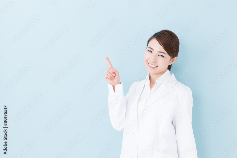 Wall mural young asian doctor on blue background