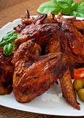 Plate of chicken wings on wooden background