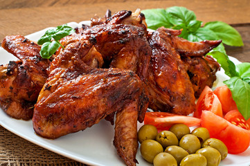 Plate of chicken wings on wooden background