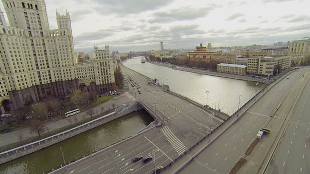 Cars ride by bridge and Kotelnicheskaya quay and cityscape
