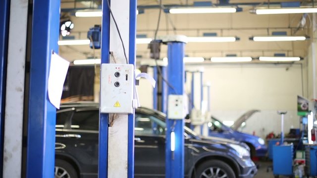 Cars wait repairing and blue lifts at modern Service station
