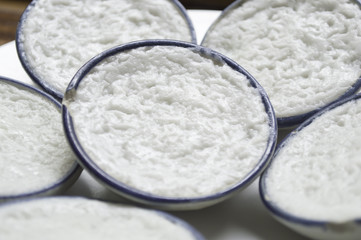 Close up coconut milk custard in small porcelain cup.