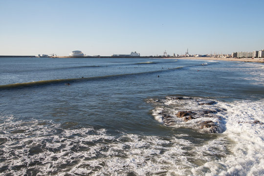 Waves and surfers at Porto, Portugal.