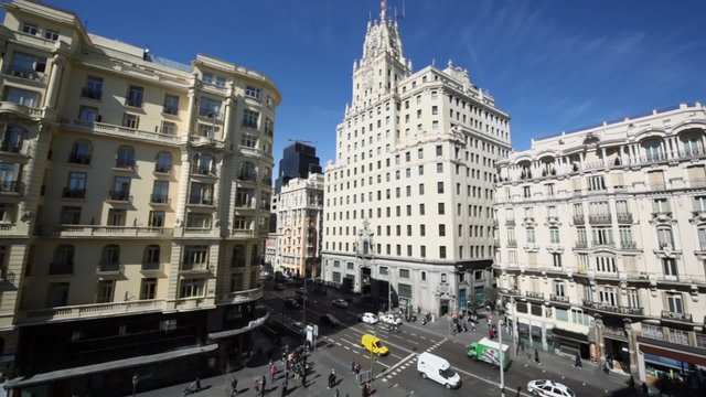 Cars ride by Gran Via street near Telefonica building