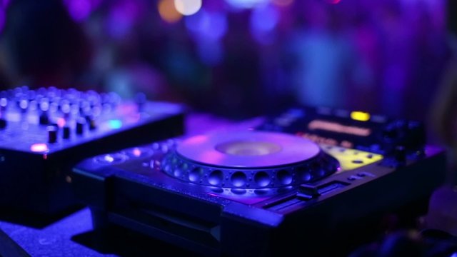 CD-player and mixer on DJ table in nightclub during party