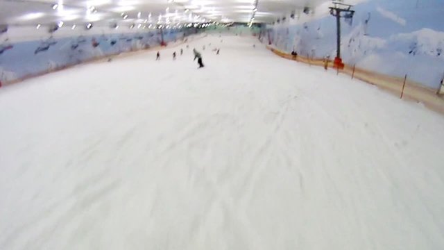 Skier rushes on snow slope of mountain in skiing center