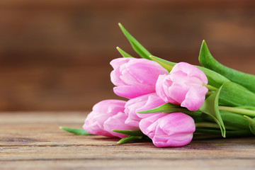 Beautiful pink tulips on wooden background