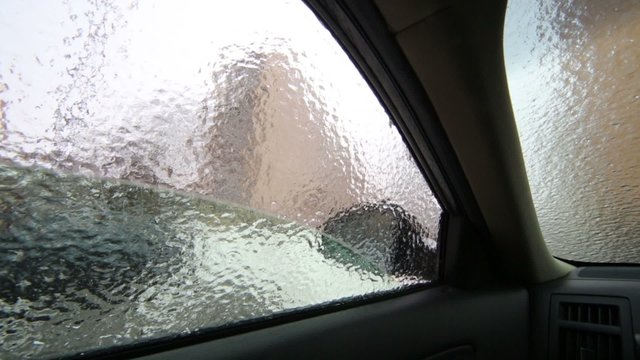 Inside view to crust of opaque ice on the outside car windows.
