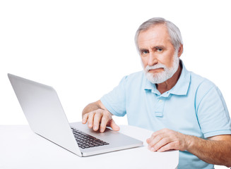 Fototapeta premium Senior man working on laptop, isolated on white