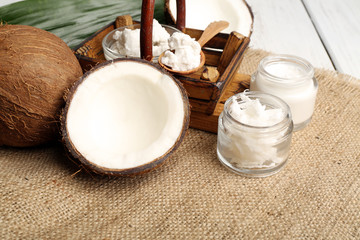 Coconut with jars of coconut oil and  cosmetic cream