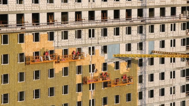 Weatherization works on building wall at construction site 