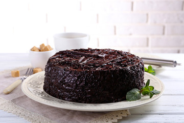 Tasty chocolate cake with mint on table close up