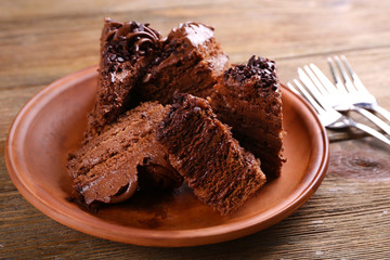 Slices of tasty chocolate cake on plate on table close up