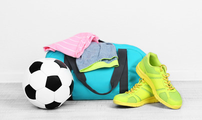 Sports bag with sports equipment in room