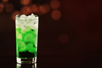 Green cocktail on table on brown background