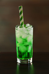 Green cocktail on table on brown background