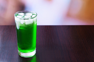 Green cocktail on table on light background