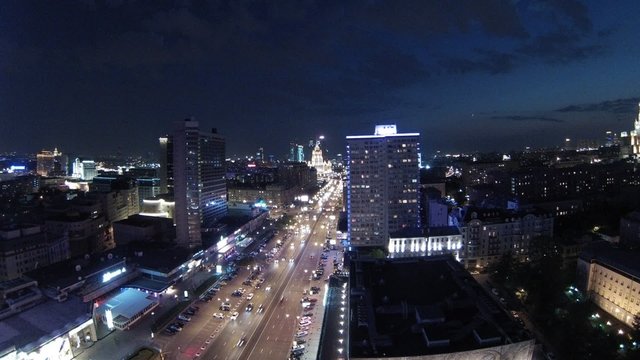 Car traffic at night on big illuminated street, wide view