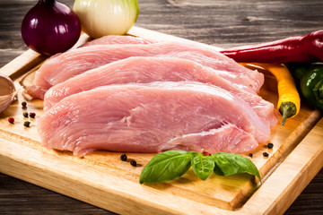 Raw chicken breasts on cutting board