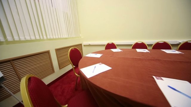 empty conference room with oval table and carpet on floor