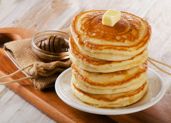 Stack of Small pancakes with maple syrup on  a wooden table