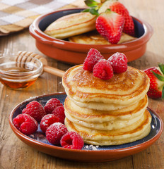 Small pancakes with fresh raspberries and  butter