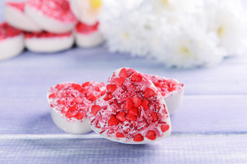 Delicious chocolate candies in heart shape on table close-up
