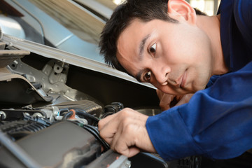 Auto mechanic checking car engine