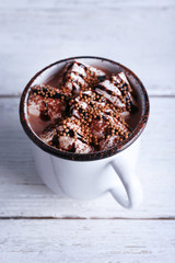 Mug of cocoa with marshmallows on wooden background