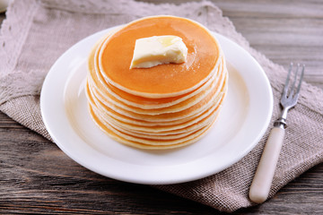Delicious pancakes with honey on plate on table close-up