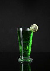 Flaming green cocktail on dark background