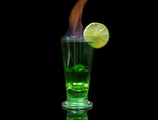 Flaming green cocktail on dark background
