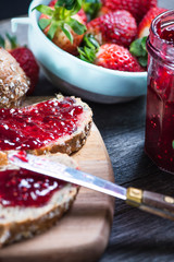 spreading strawberry jam on bread