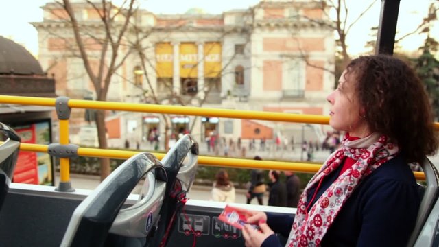 Beautiful young woman listens tour program at tourist bus