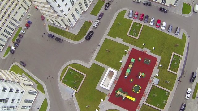 Parking with cars and playground in middle of building complex
