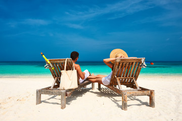 Couple in white relax on a beach at Maldives