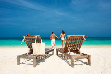 Couple in white running on a beach at Maldives