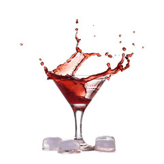 Red wine make splash into glass near ice cubes