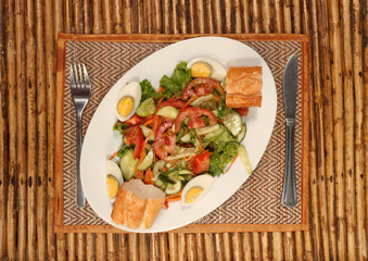 Hard boiled egg with vegetable salad and baguette