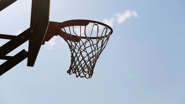 Sportsman throws ball into basket on Dudu Streetbasket fest