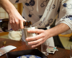 Man pouring sake into flask, Japan