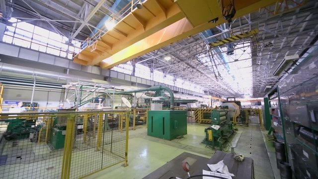 Overhead crane moves in workshop with equipment