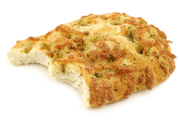 freshly baked focaccia bread with a bite missing on a white back