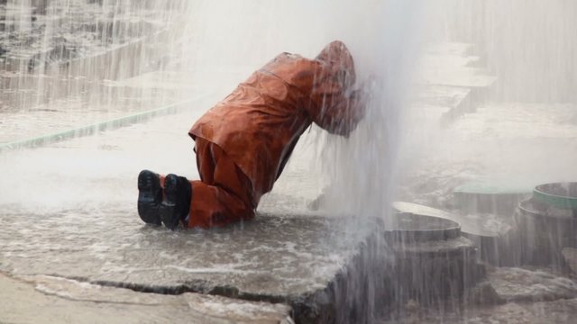 Worker in overalls eliminates breakthrough of sewerage system