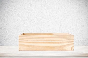 Empty white wooden table over white cement wall background