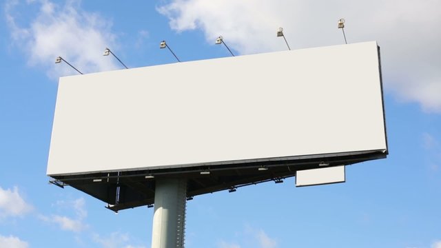 Blank billboard at background of blue sky with moving clouds